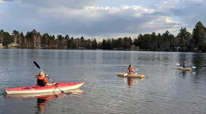 3 kids in various sized kayaks