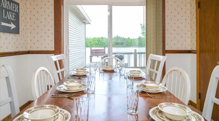 Table settings in Cottage 1 looking out the patio door at the lake