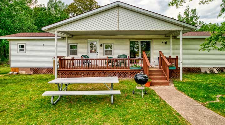 Picnic table and charcoal grill in front of Cottage 6 porch