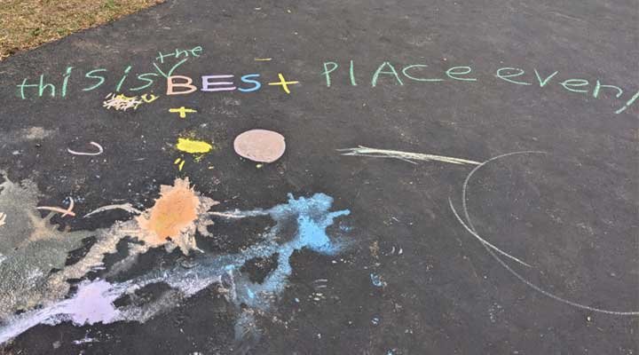 Chalk on driveway says "This is the Best Place ever!"